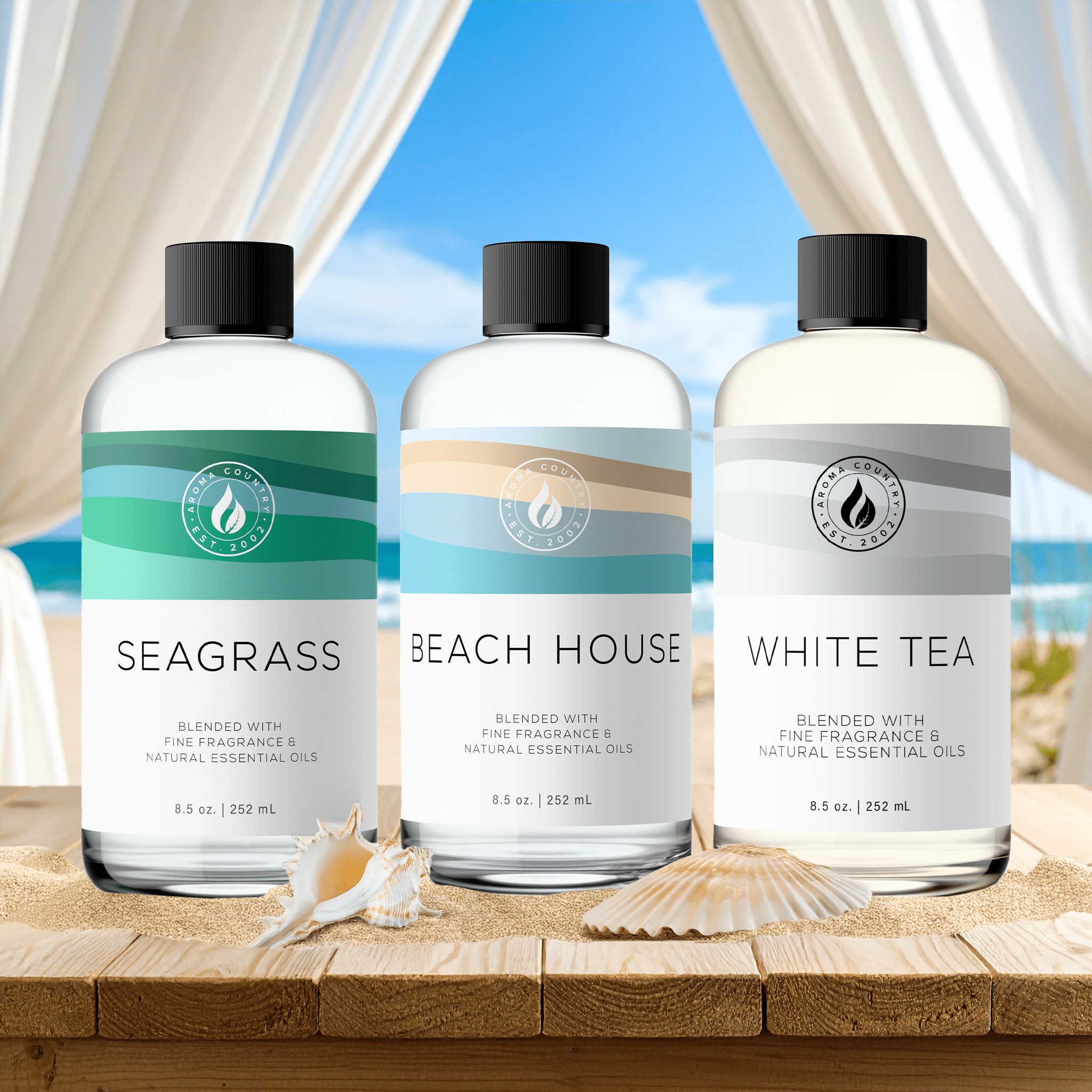 Coastal Escape fragrance trio of Beach House, Seagrass, and White Tea oils set against a beach backdrop with soft sand and ocean breezes