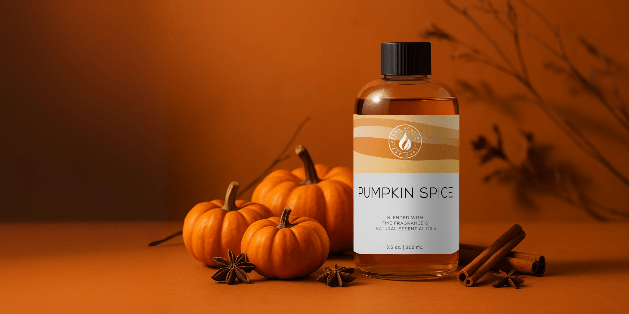 Aroma Country's 8.5 oz Pumpkin Spice diffuser oil bottle with mini pumpkins and autumn spices on a warm orange background.