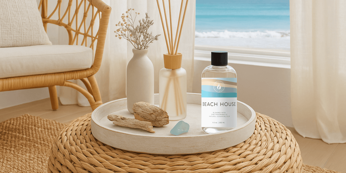 Beach House diffuser oil styled with driftwood and reeds in a coastal room overlooking the ocean