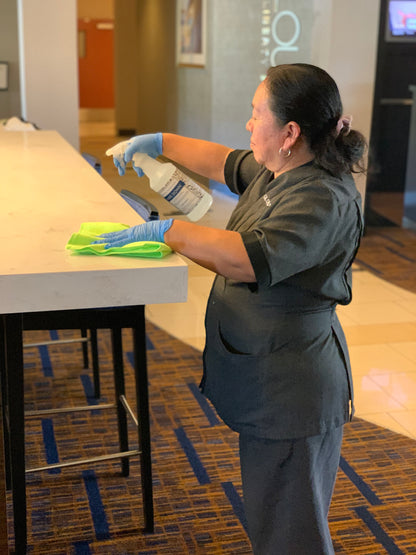 Hotel housekeeper using Wipe Down to clean a countertop.
