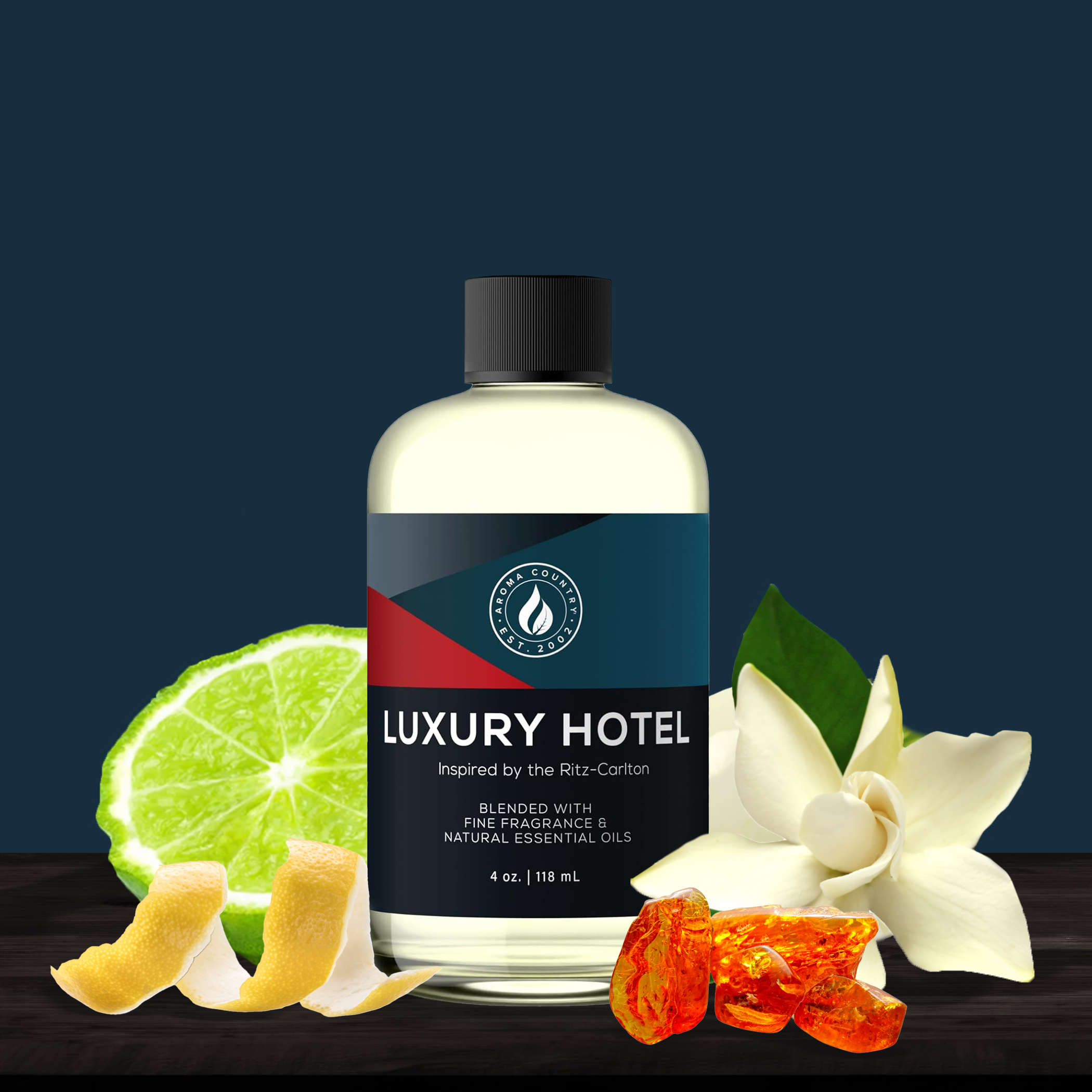 Bottle of 'Luxury Hotel' with lime, orange peel, and white flowers on a dark background