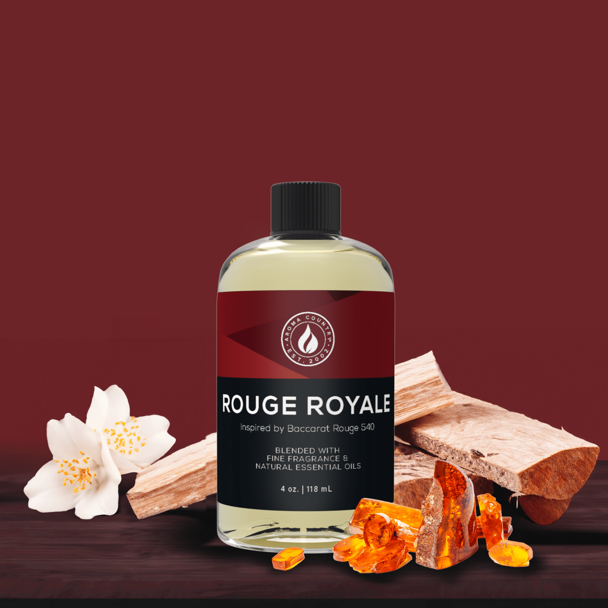 4oz bottle of Rouge Royale diffuser oil inspired by Baccarat Rouge 540, shown with amber resin, jasmine petals, and sandalwood on a deep red background.
