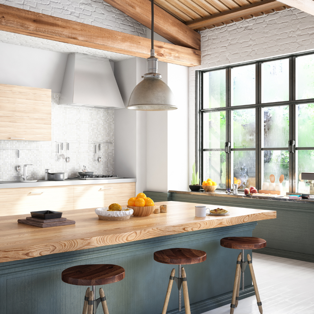 Bright kitchen with natural wood accents, exposed ceiling beams, a large window, and a breakfast bar set with fruit and coffee.