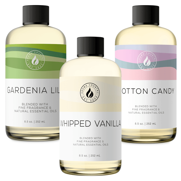 Sweet Comfort aroma oil bundle in 8.5 oz bottles featuring Gardenia Lily, Whipped Vanilla, and Cotton Candy, pairing creamy floral, soft vanilla, and sugary confection character for a gentle gourmand-floral scent collection