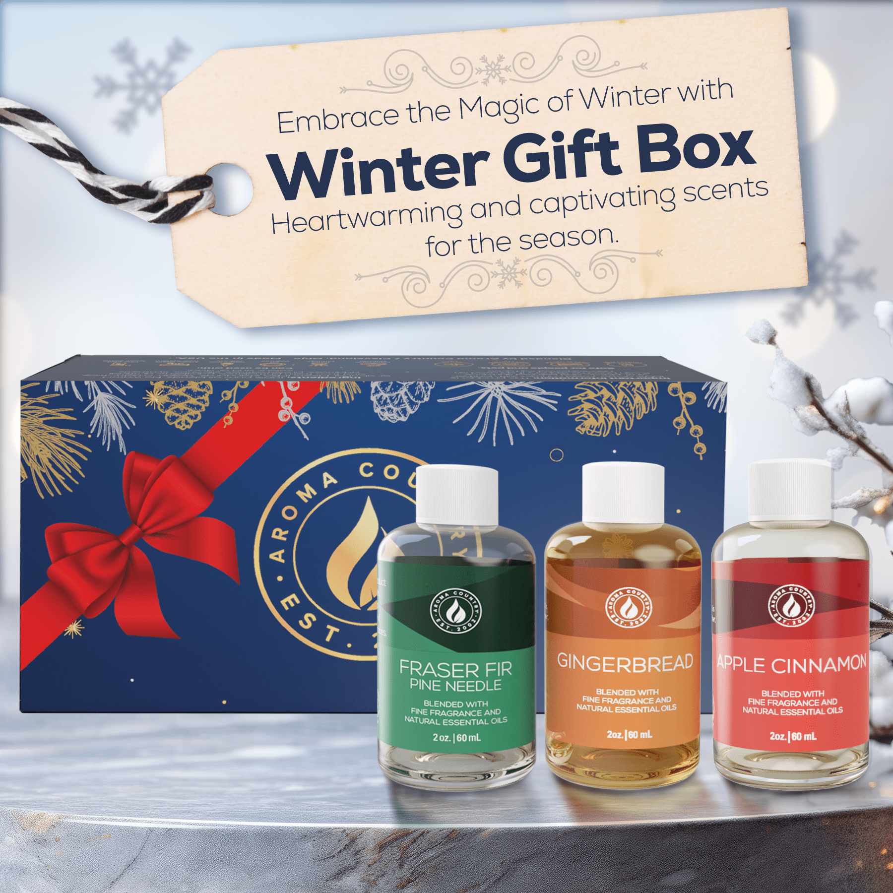 Fraser Fir, Gingerbread, and Apple Cinnamon essential oils displayed in front of a festive winter gift box.